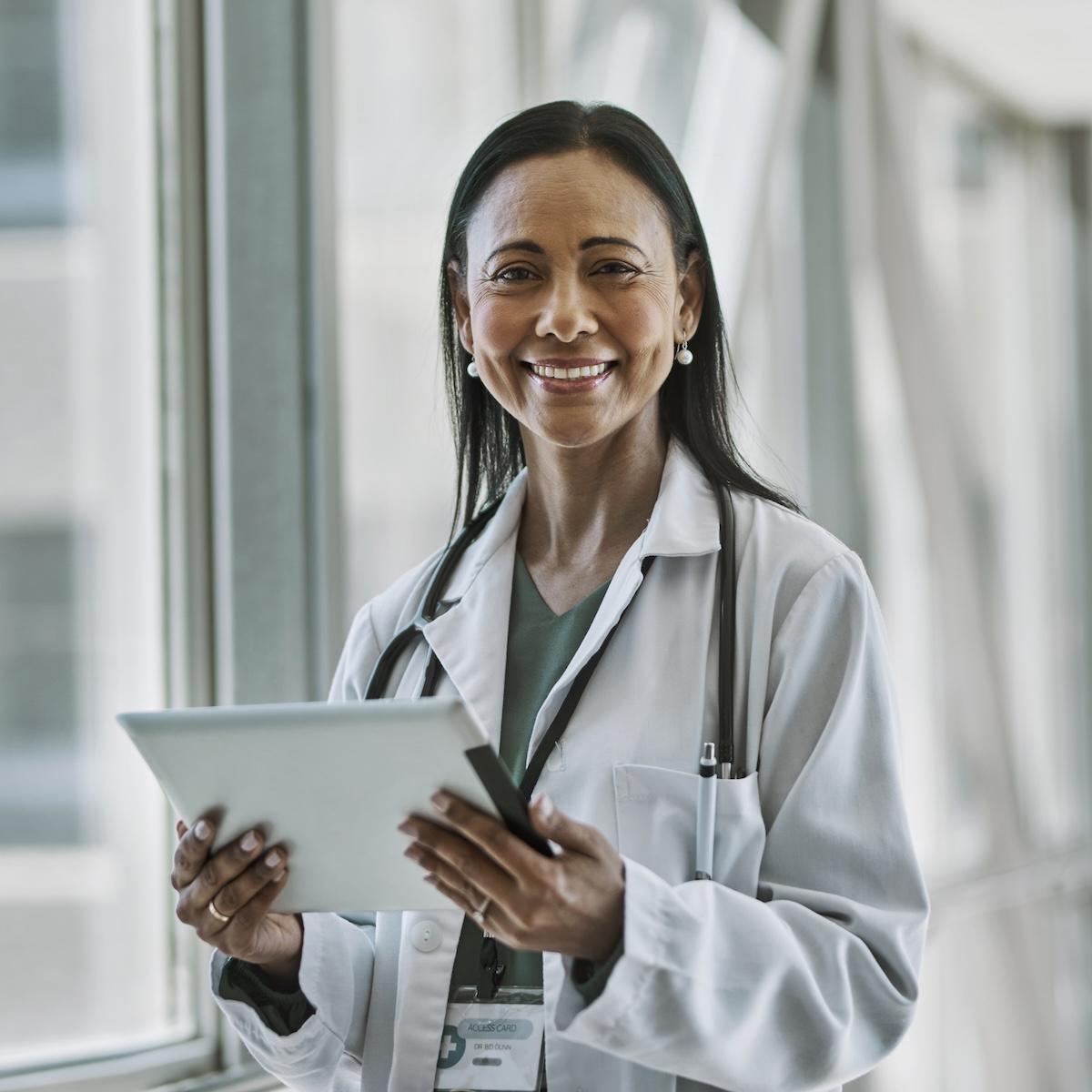 smiling clinician holding tablet 