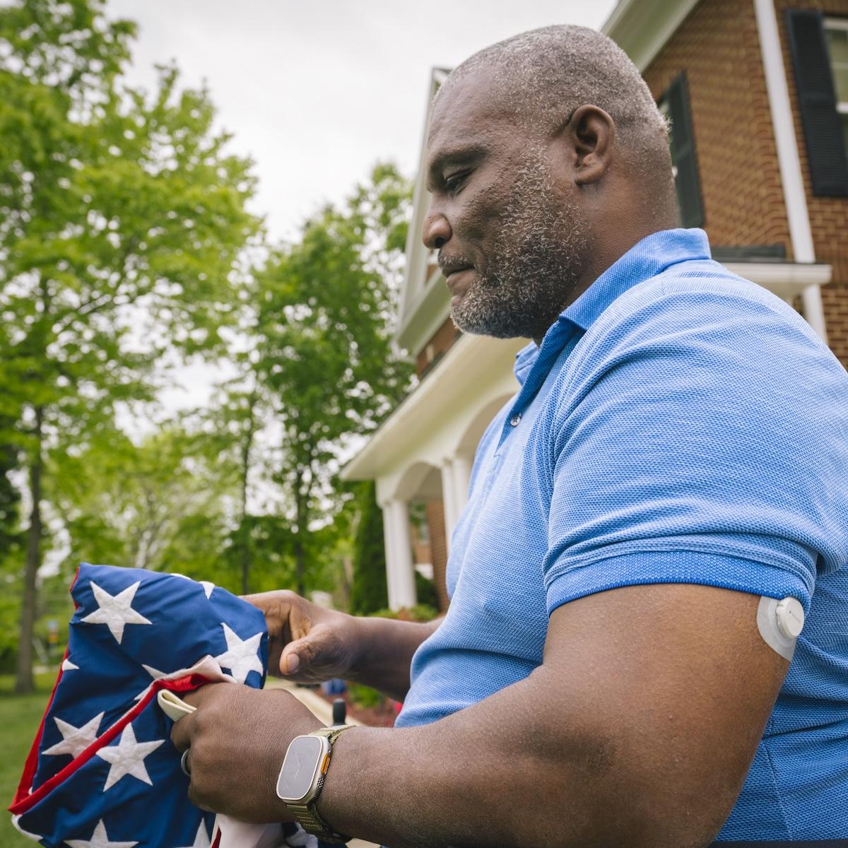 dexcom-g7-dtc-man-veteran-folding-american-flag
