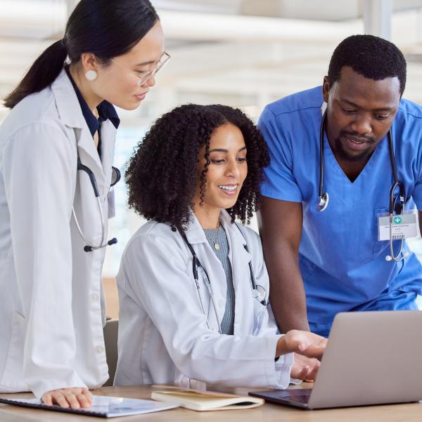 three healthcare providers looking at laptop