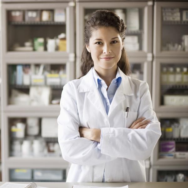 pharmacist in white coat in front of medicine cabinet